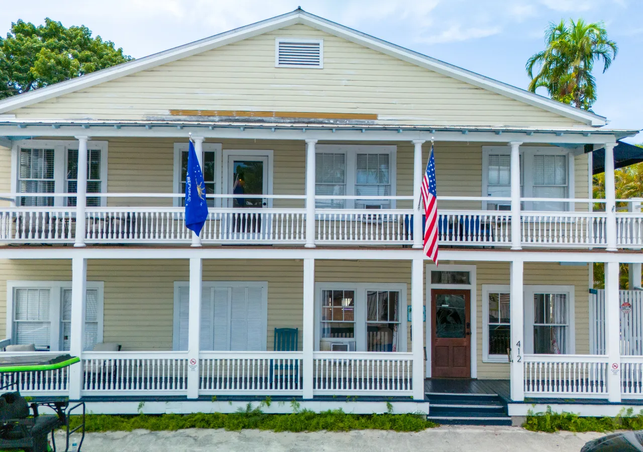 A two-story building with a large porch and balcony